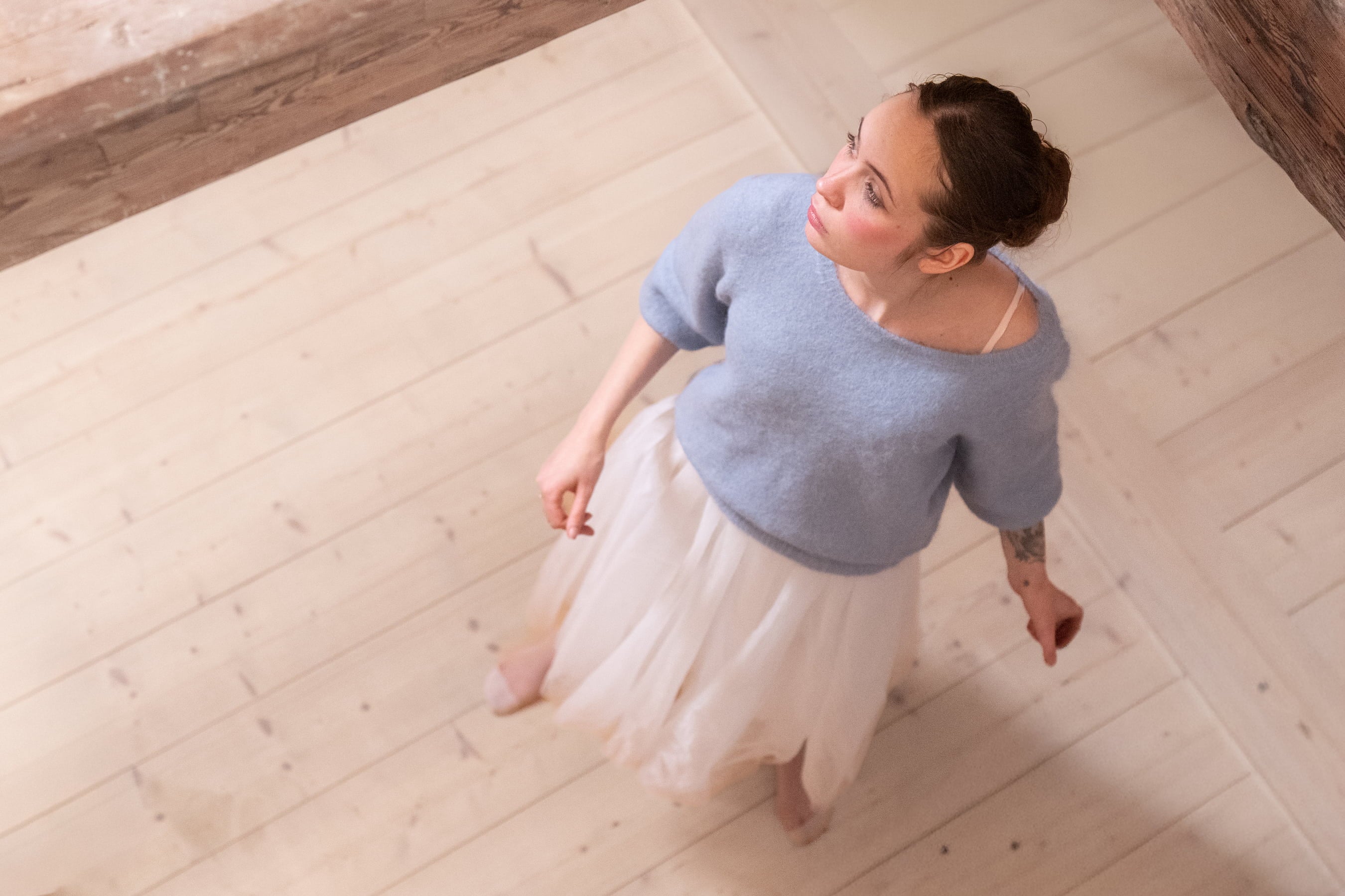 Woman wearing light blue Adele & Soleil knitwear, photographed from above.