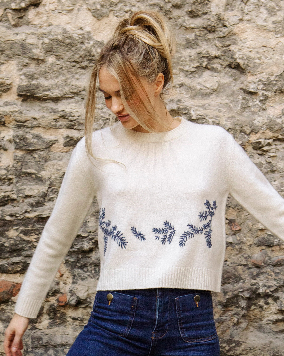 Close-up of the hand-embroidered floral detail on the natural white Adele & Soleil Jour de Soleil sweater, front view.