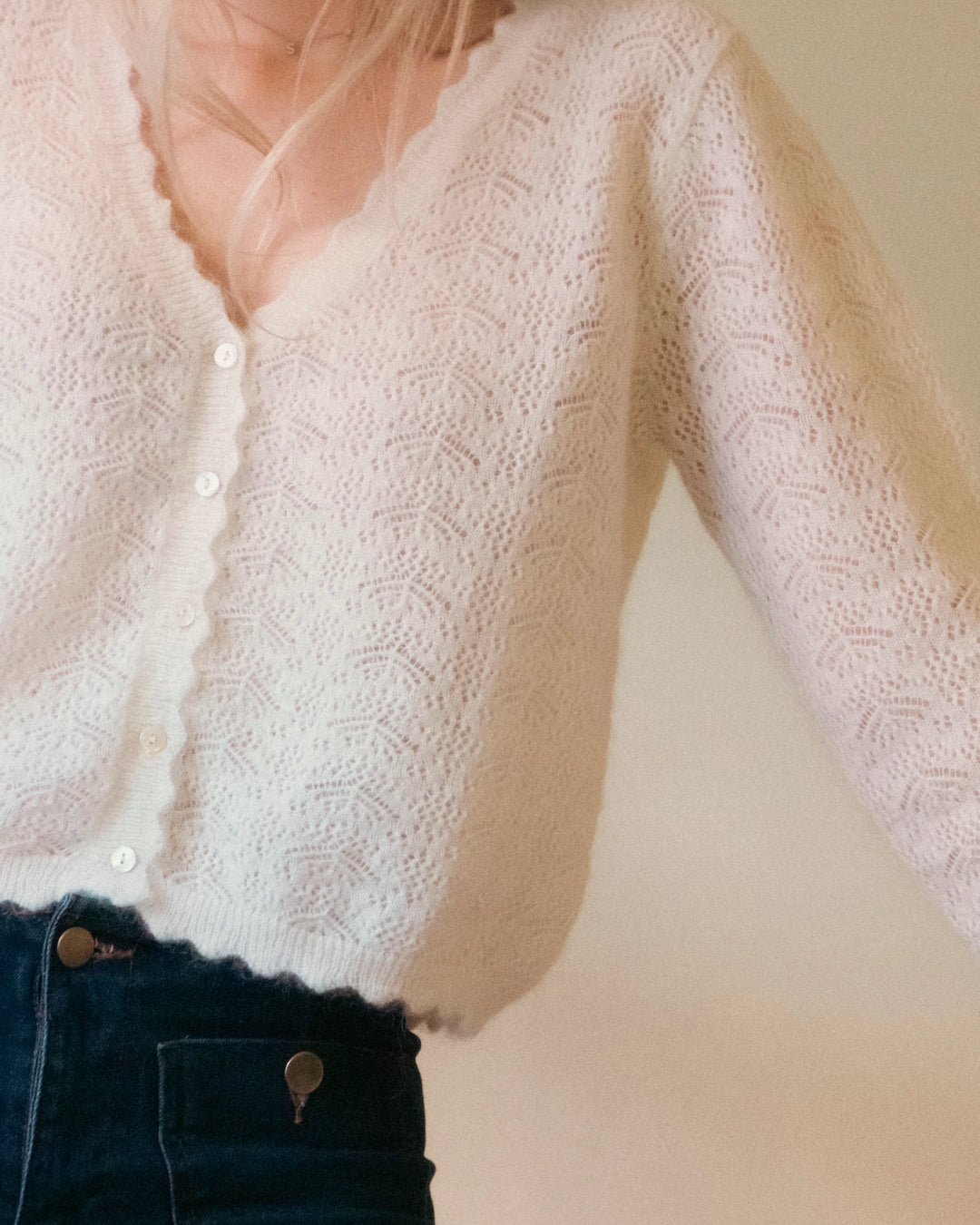 Close-up of the natural white Adele & Soleil Fée V-neck knit sweater, front view.