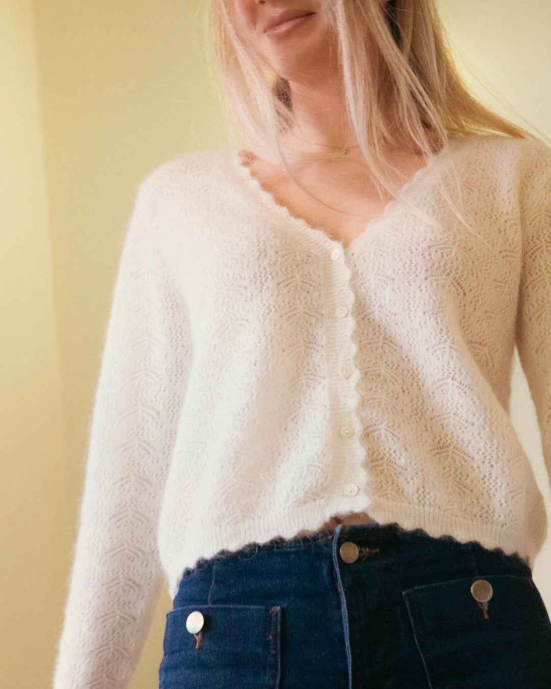 Woman standing in the natural white Adele & Soleil Fée V-neck knit sweater, front view.