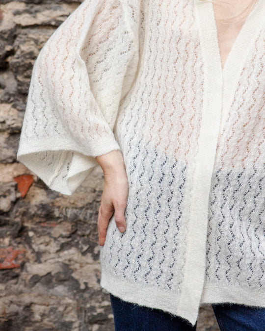 Close-up of the wide kimono sleeve and textured knit of the Adele & Soleil Jasmin natural white wrap cardigan.