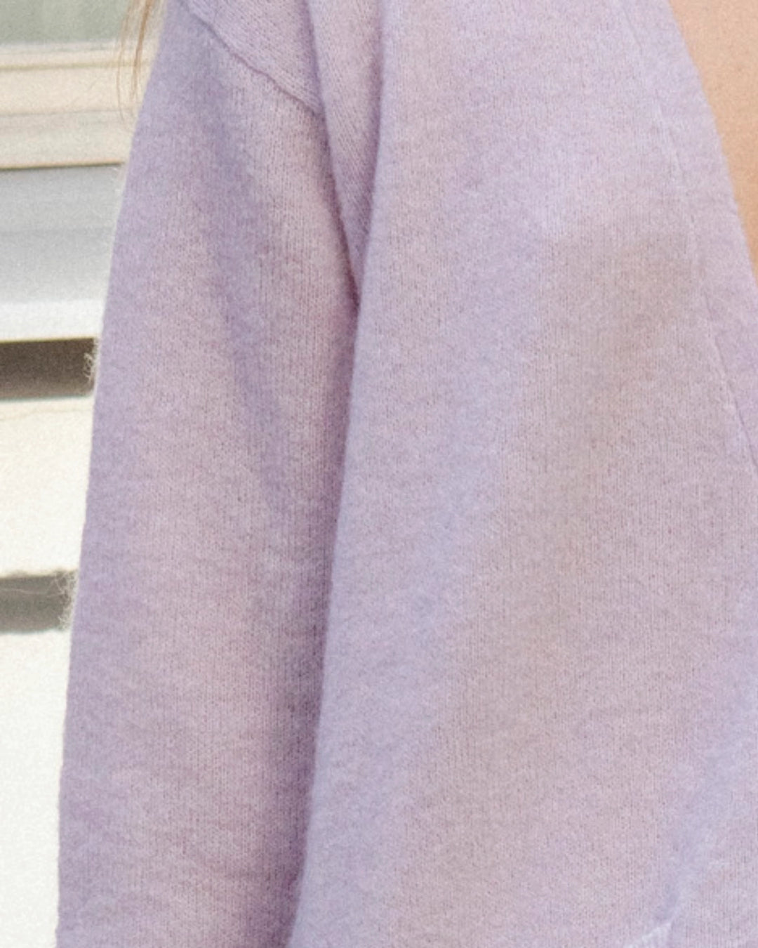 Close-up of the soft textured knit and button-front detail of the Adele & Soleil Lundi Matin light lilac cardigan.
