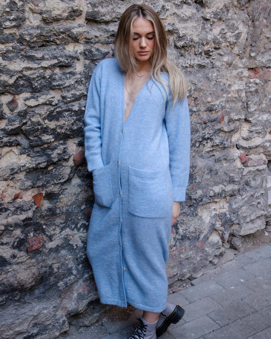 Full-length front view of a woman wearing the Adele & Soleil Lundi Matin sky blue cardigan with buttons and patch pockets.