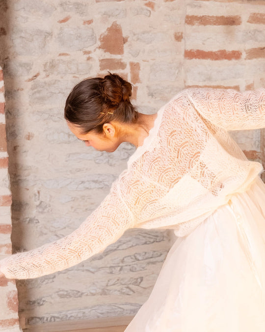 Woman dancing in the natural white Adele & Soleil Rêve V-neck sweater, back view.