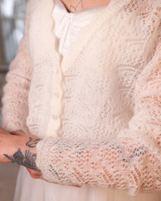 Close-up of the neckline and front knit detail of the natural white Adele & Soleil Rêve sweater.