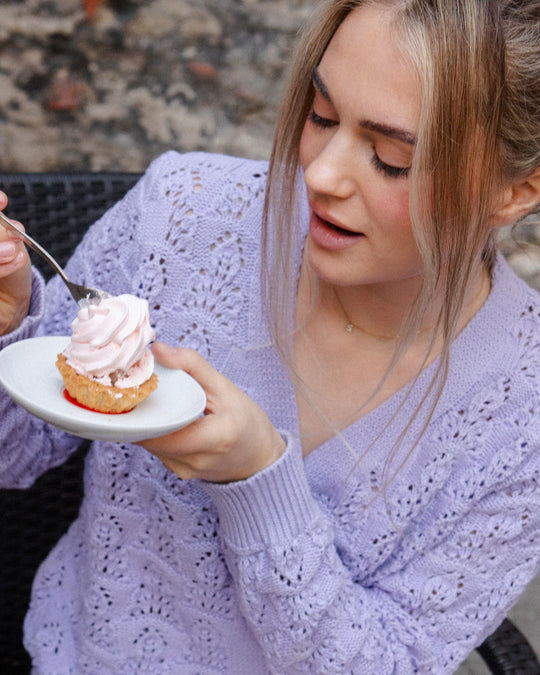 Close-up of a woman wearing the Adele & Soleil Sérène lavender cotton cardigan while holding a cup.