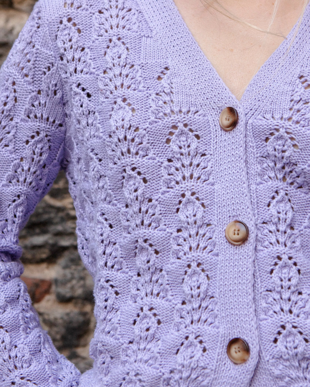 Close-up of the V-neckline, buttons, and textured pointelle knit of the Adele & Soleil Sérène lavender cotton cardigan.