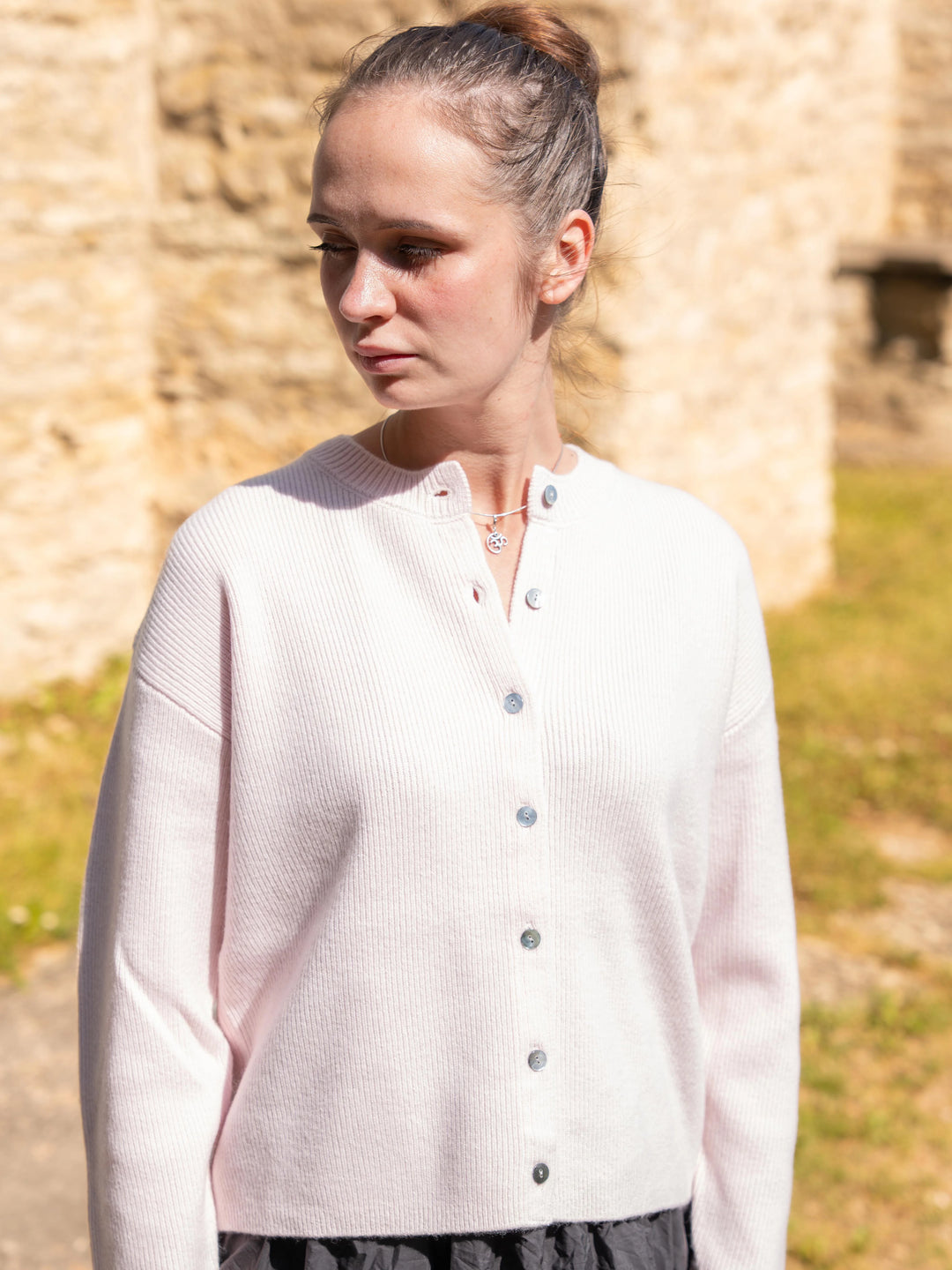 Model wearing the Toujours 100% merino wool cardigan in Light Pink
