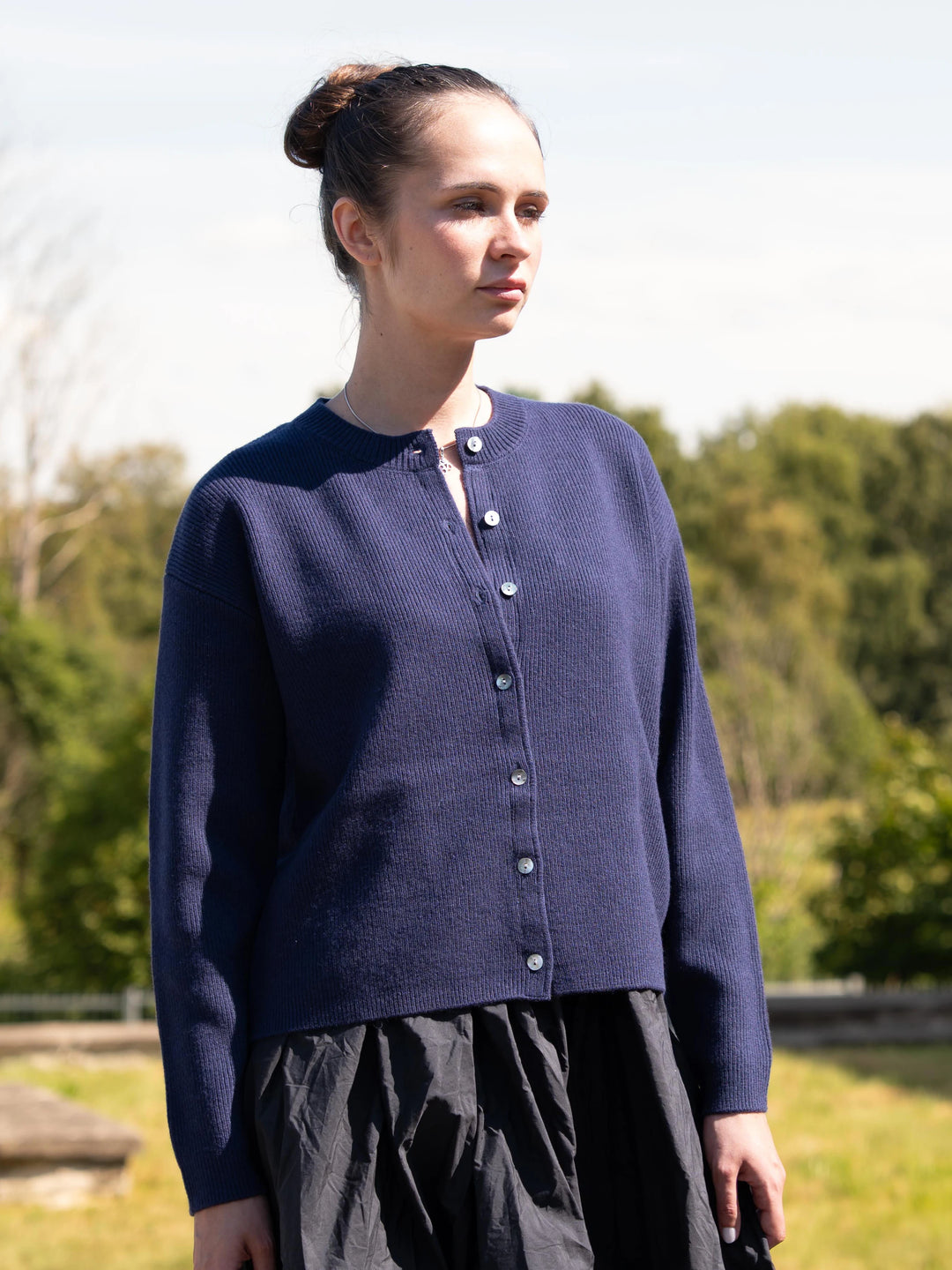 Model wearing the Toujours 100% merino wool cardigan in Navy
